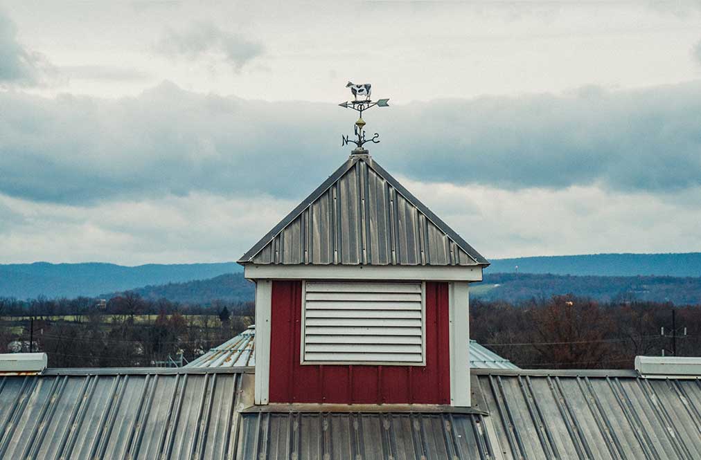 A Windvane On Top Of A Barn