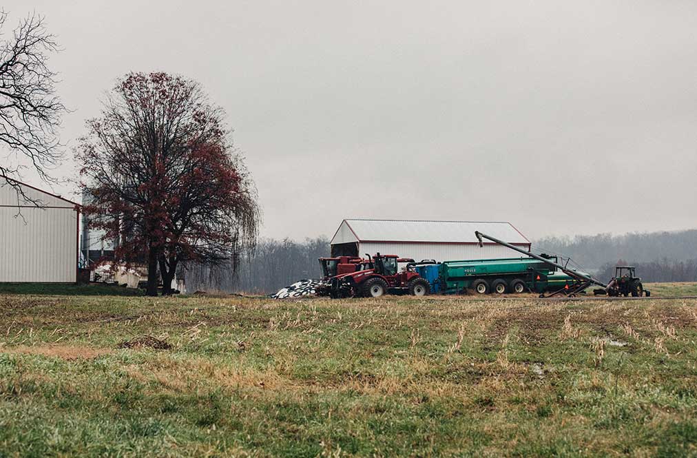 A View Of Sheds On A Farm With Machinery Nearby